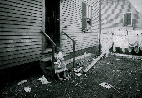 Annie Fedele crocheting on underwear out in the filthy back yard. This is one of the places she works on crochet 1912