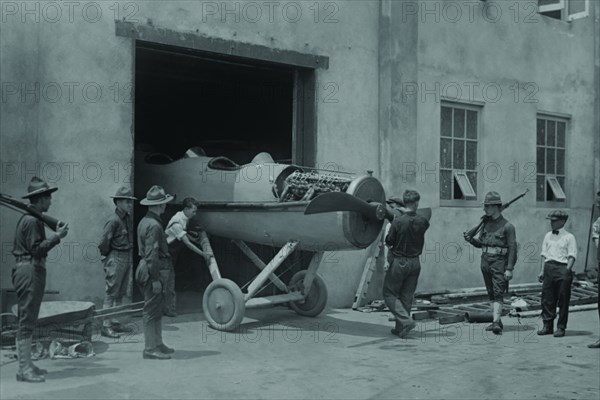 At college point aircraft manufacturing plant in Queens, New York, a Fighter sans wings is moved out the plant door for finally assembly and shipment to Europe to fight in the Great War 1917