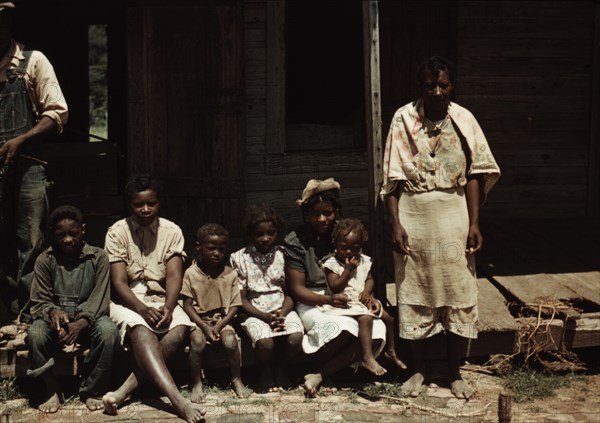 Bayou Bourbeau plantation, a FSA cooperative, Natchitoches, La. A Black family seated on the porch of a house 1940