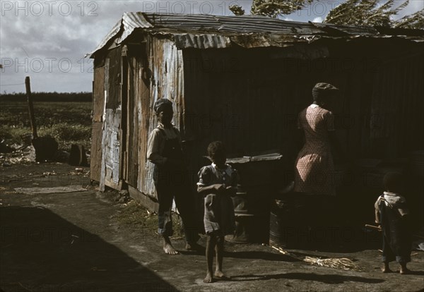 Black migratory workers by a shack, Belle Glade,  1941