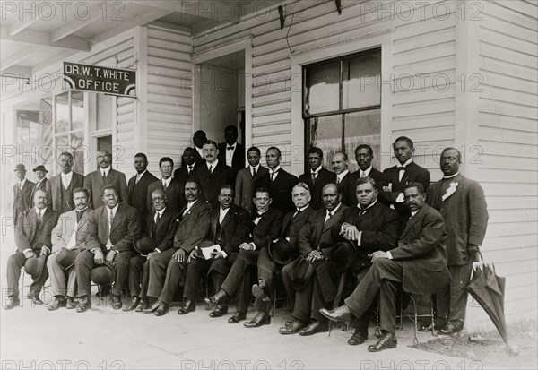 Booker T. Washington seated with group of men  1915