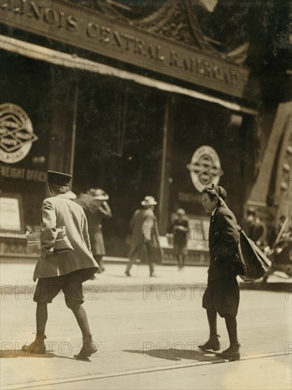 Bundle Boys carry packages as messengers outside of Illinois Central Railroad Station 1910