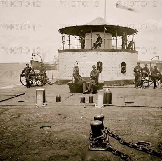 Charleston Harbor, S.C. Deck and officers of U.S.S. monitor Catskill; Lt. Comdr. Edward Barrett seated on the turret 1864