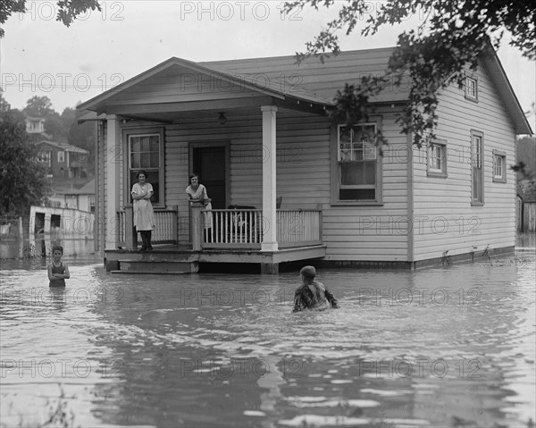 Children on porch of house surrounded by flood 1922
