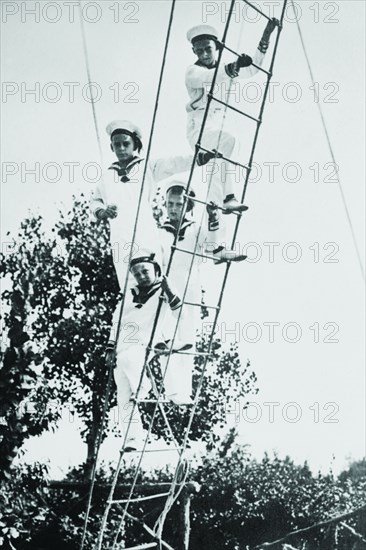 Crown Prince of Germany's Children frolic on what appears to be a ship's ratline or rope ladder