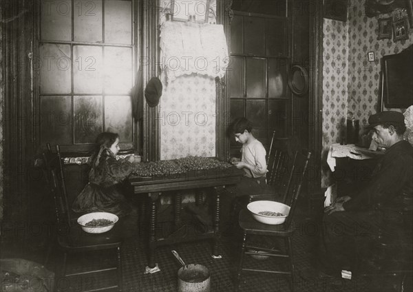 Italian Family picks nuts in their tenement apartment 1911