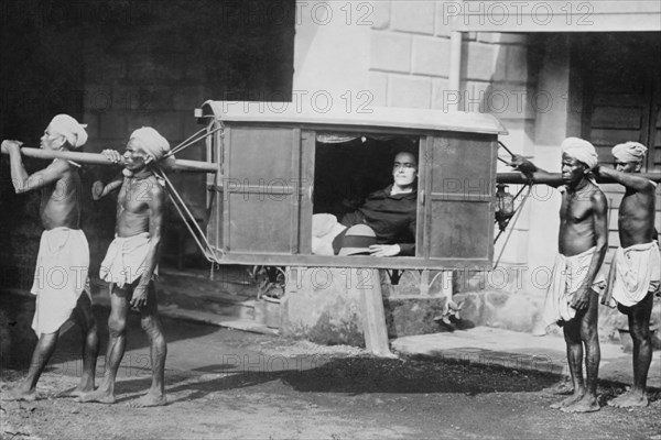 Four Indian Porters Carry a Westerner in a palanquin or Sedan Chair 1922