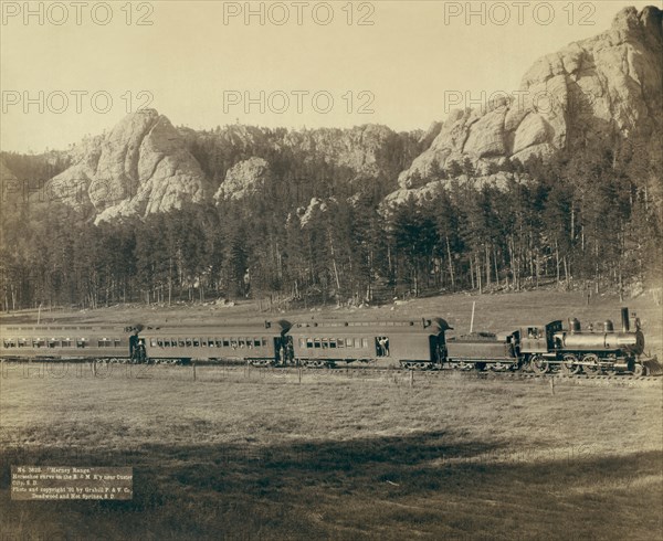 Full view of as train coming through the mountains in the West 1891