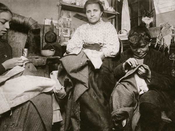 High up on the top floor of a rickety tenements, immigrants, this mother and her two children were living in a tiny one room, and were finishing garments.  1924