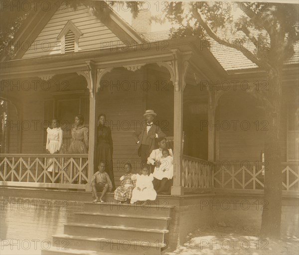 Home of an African American lawyer, Atlanta, Georgia, with men, women, and children posed on porch of house 1899