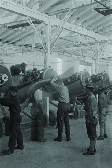 In the College Point Assembly Plant, Propellers are mounted on monoplane fighters under military supervision so the aircraft will be ready for shipment to Europe in the Great War. 1917