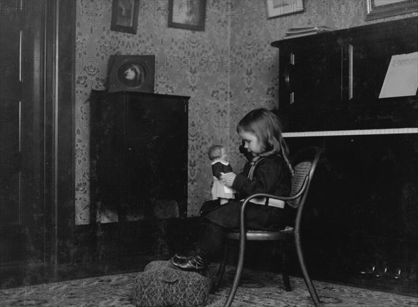 Little girl conversing with a Campbell Kid. 1912