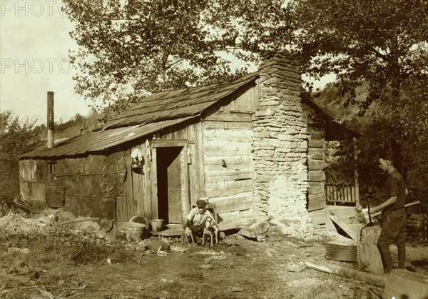 little log cabin, - relic of the old days, - now occupied by a small family (F. T. Castle) who are gradually giving up farming and depending upon mining and odd jobs. Oct. 12, 1921. (Dogs). Location: Big Chimney, West Virginia 1921