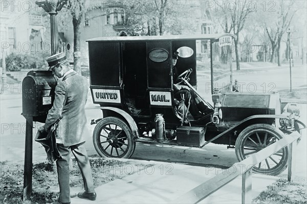 Mailman at Post Box with his truck parked at the curb 1925