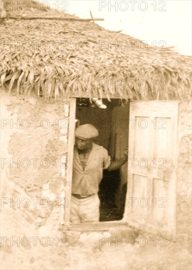 Man standing at door of house, looking out, possibly from the visit by Alan Lomax and Mary Elizabeth Barnacle to Cat Island in the Bahamas 1935