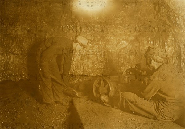 Man with punching machine to drill into coal.  1908