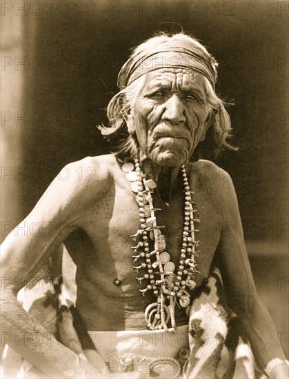 Many Goats, Navajo Indian, half-length portrait, seated, facing slightly right 1913