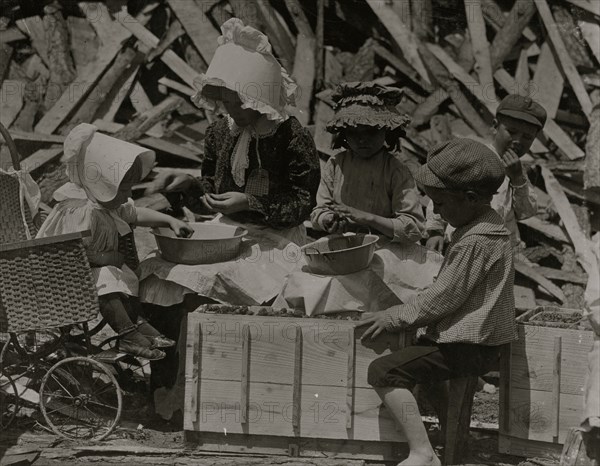 Mother and children hulling strawberries at Johnson's Hulling Station. 1911