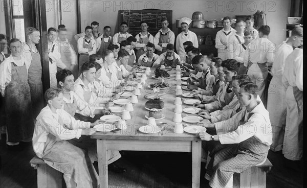 Naval Cadets sit at long table with bowls in front