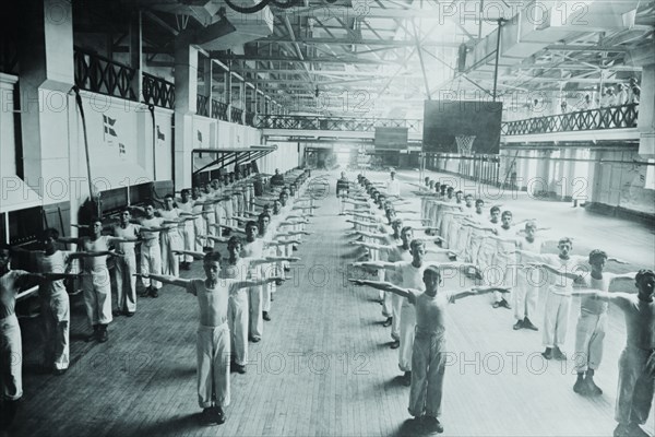 Naval Cadets exercise in large hangar in their calisthenics