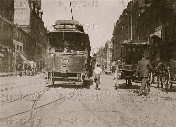 Newsboy starting to "flip a car." 1909