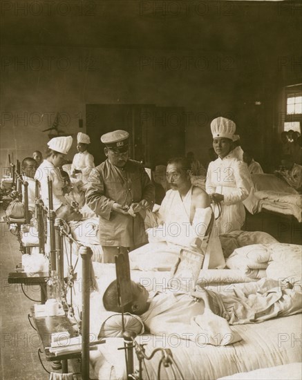 Nurses and a doctor attending wounded soldiers on a hospital ward 1905