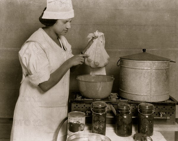 One of the Cabel County Demonstration Team demonstrating the process of blanching tomatoes to visitors at the 4 H Club Fair.  1921