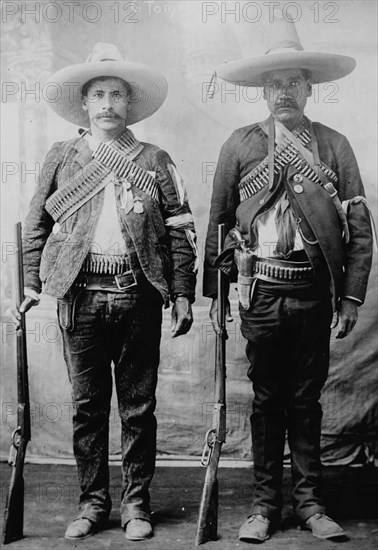 Pancho Villa's Men Urbino & Iluarte stand at attention with rifles, bandoliers and Pistols 1917