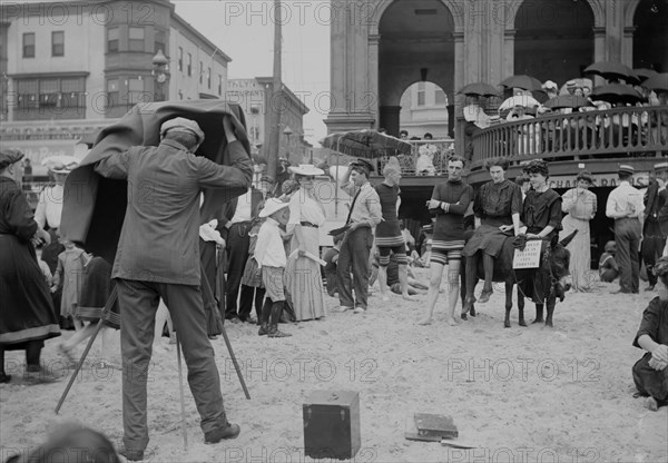 Photographer taking picture of group with donkey at crowded beach, Atlantic City, N.J.