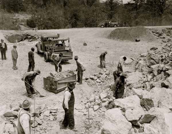 Prisoners breaking up rocks at a prison camp or road construction site 1941