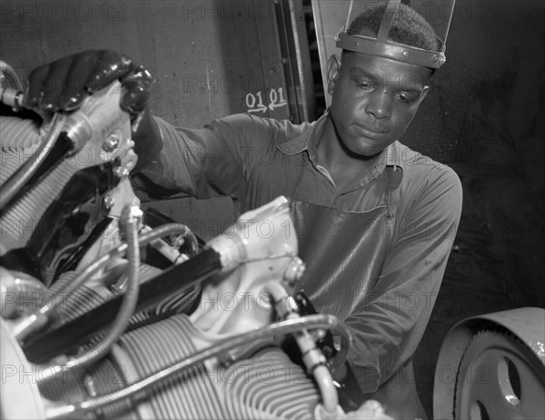 Production. Aircraft engines. A young Black worker stands ready to wash or "degrease" this airplane motor prior to its shipment. He's an employee of a large Midwest airplane plant. Melrose Park, Buick plant 1943