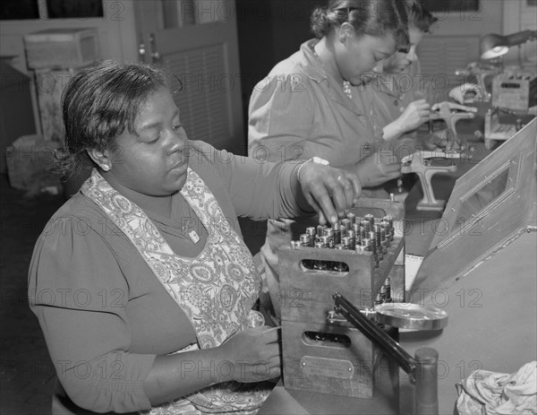 Production. Aircraft engines. Black women with no previous industrial experience are reconditioning used spark plugs in a large Midwest airplane plant. 1943