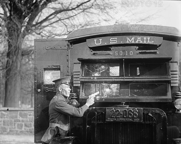 Uniformed Postal Official tests Regulation Army 44 Colt and its effect on bullet proof glass used in the new armored postal trucks 1921
