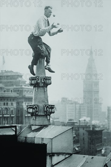 Reynolds Juggles balls on the Pinnacle of a roof  high above New York City