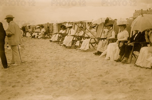 Spectators seated in beach chairs with awnings watches the motor boat races at Palm Beach, Florida 1910