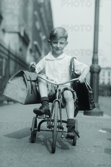 Toddler on Tricycle Carries small satchels after making a food sale