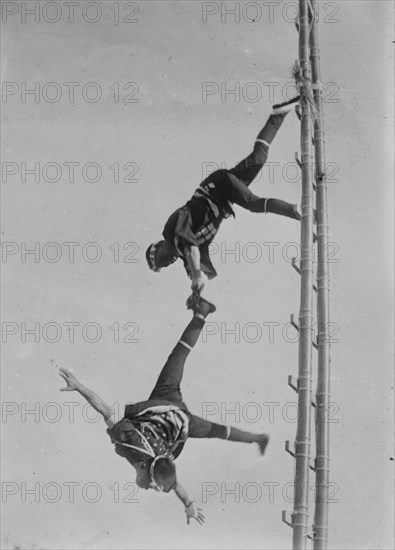 Two Tokyo Firefighters display acrobatic skill on very high bamboo ladders