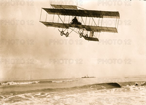 M. Van den Born flying above the sea. A ship is on the horizon