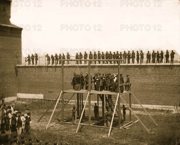 Washington, D.C. The four condemned conspirators (Mrs. Surratt, Payne, Herold, Atzerodt), with officers and others on the scaffold; guards on the wall 1865