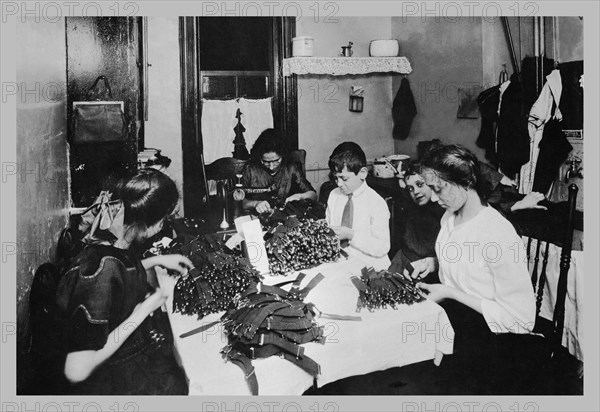 Family Sitting at Table Working with Garters 1900