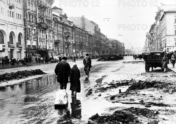 world war ll: taking a dead family member to the cemetery along nevsky prospect in leningrad during the blockade, 1942.