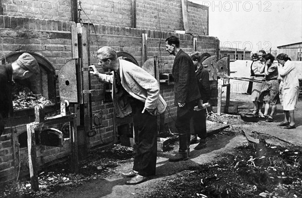 Lublin murder camp [,,,] the batteries of inciner-[,,,]at disposed of the bodies  lublin, poland lublin residents examine victims' remains in ovens of madjanek concentration camp.