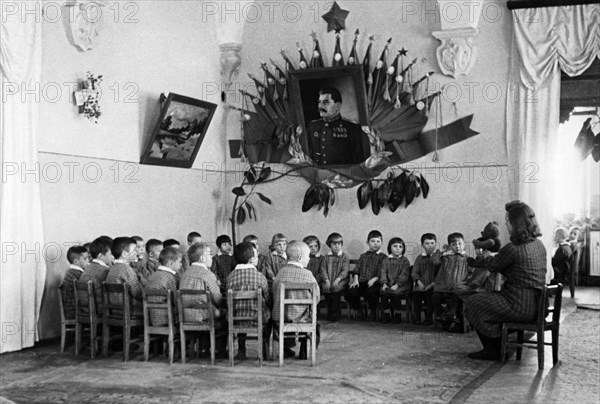 Students listening to their teacher tell a story at a kindergarten for miner's children in the soviet union, 1948.