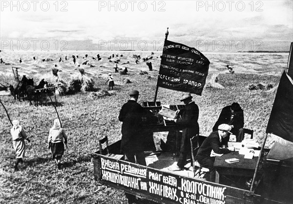 The district newspaper 'collective farmers' is being produced in the fields of the 'lenin's way' collective farm in the village of vilshanka in the shashkovsky district of the kiev region in ukraine in the 1930s.