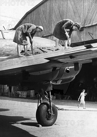 Two women working on the metal covering of a wing of a soviet military plane during world war 2, september 1944.