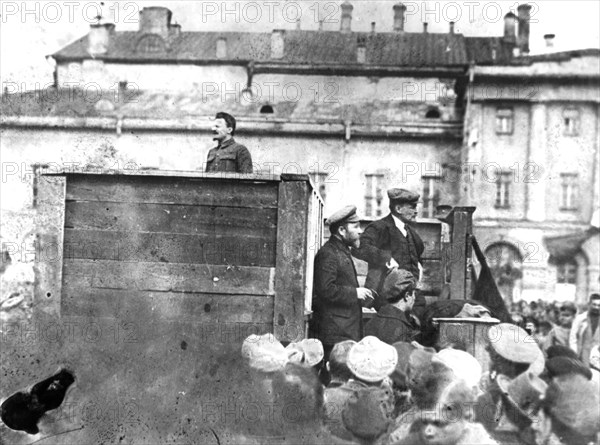 Leon trotsky addressing troops on their way to the polish front (civil war period), may 5th 1920, sverdlov square, moscow, on the stairs behind the speakers' platform are lev kamenev (in peaked cap) and v,i, lenin.