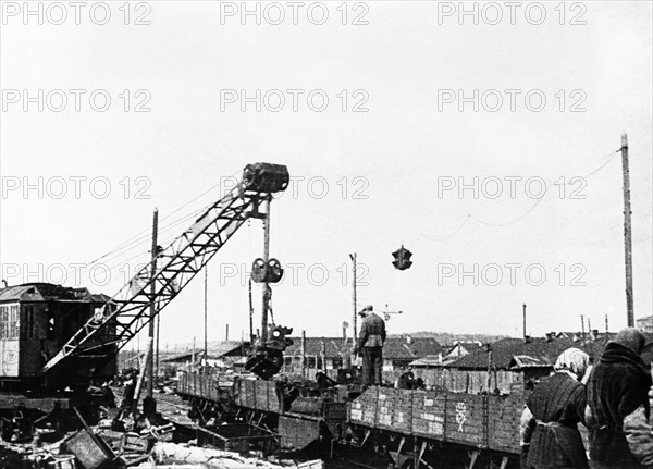 Dismantled factory machinery being loaded onto railroad cars for shipment to the urals, 1941.