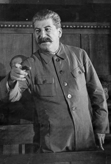 Joseph stalin giving a speach at a session of the commission for studying the project of the model constitution of agricultural artels during the second all-union congress of collective farm shock-workers, april 1935.