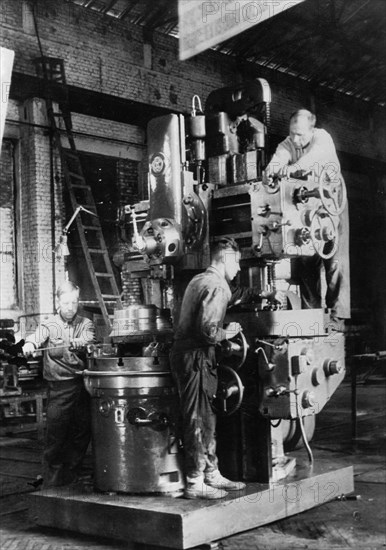 War time restoration of the krasnodar machine tool manufacturing plant is under way, a vertical boring and turning machine, assembled by a, bershadsky and his crew, is completed 20 days ahead of schedule, ussr 1940s.