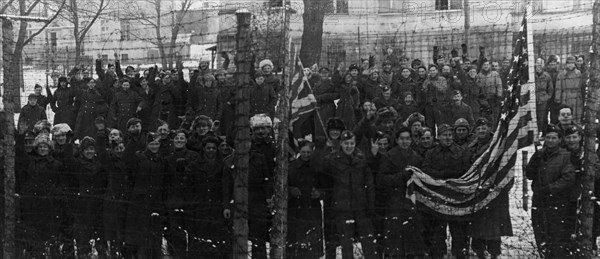 The red army freed them, americans and british prisoners of war in the yard of a german prison camp, near poznan,  they wanted to have their pictures taken behind the barbed wire fence, which separated them from the rest of the world for several years.